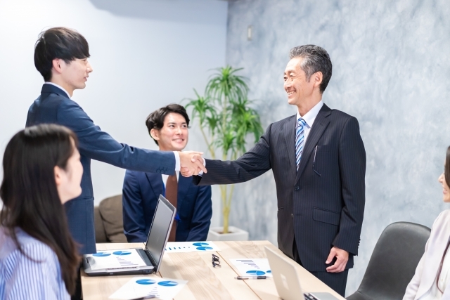 会議室で握手するビジネスマン