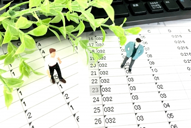 数字が印刷された紙の上に置かれた人の人形