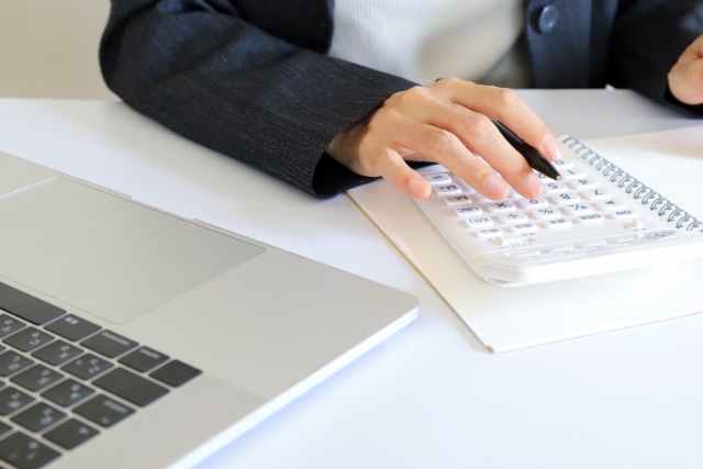 電卓で計算する女性