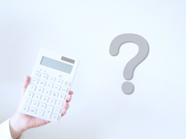 電卓の横に浮かぶクエスチョンマーク