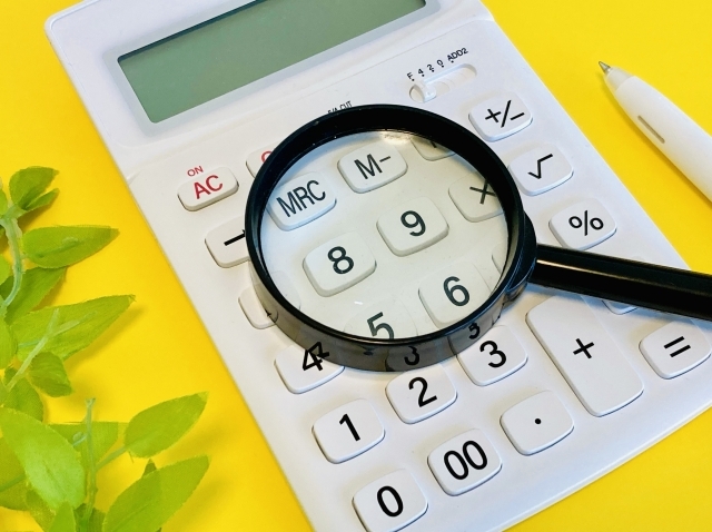 電卓の上に置かれた虫眼鏡