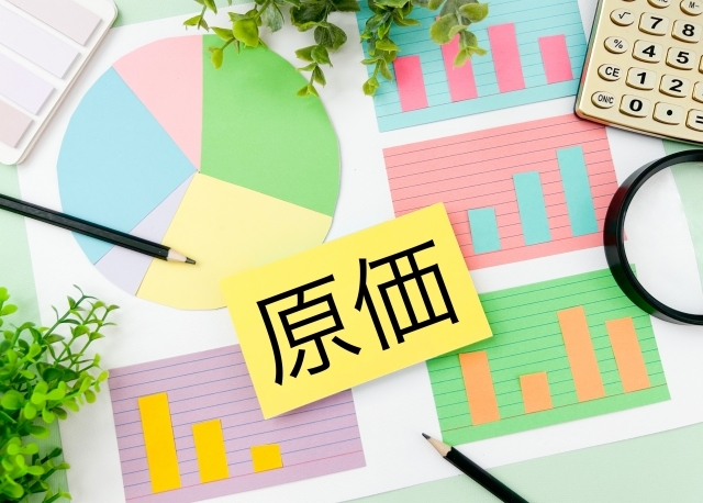 グラフの上に置かれた原価と書かれた紙