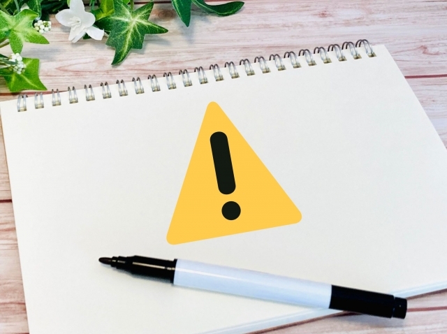 注意マークが書かれたノート