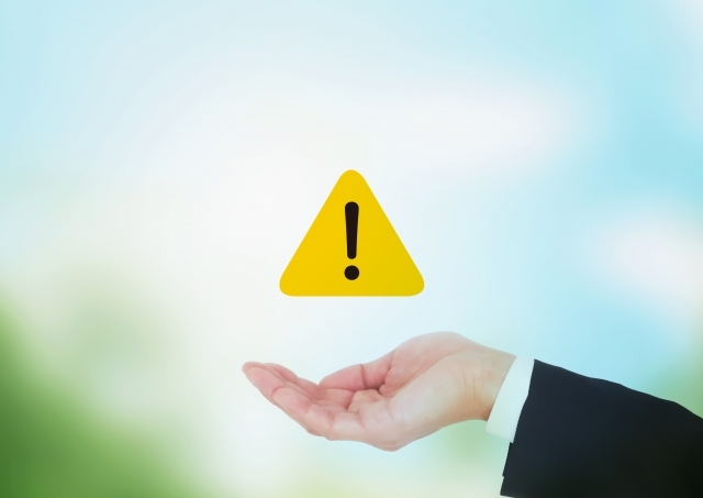 手の上に浮かんだ注意マーク