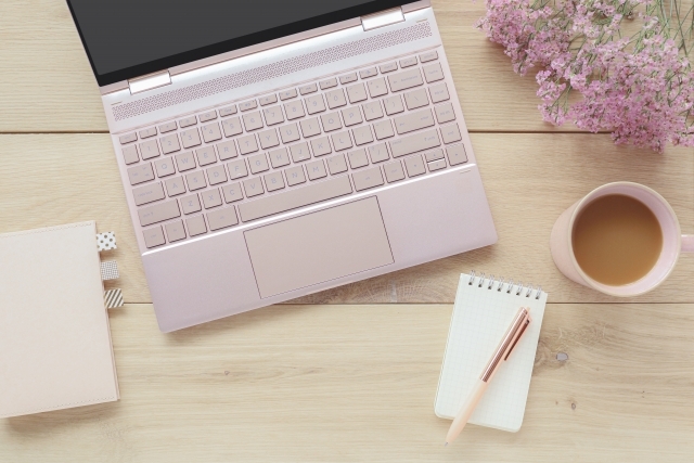 デスクの上に置かれたパソコンと手帳とメモ帳