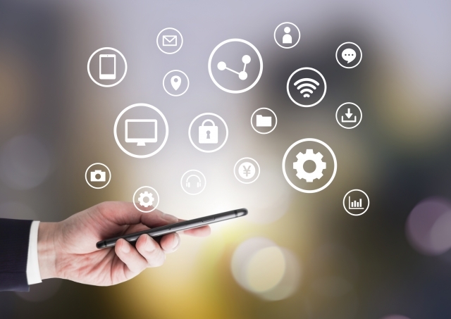 スマートフォンを持つ男性とさまざまなアイコン