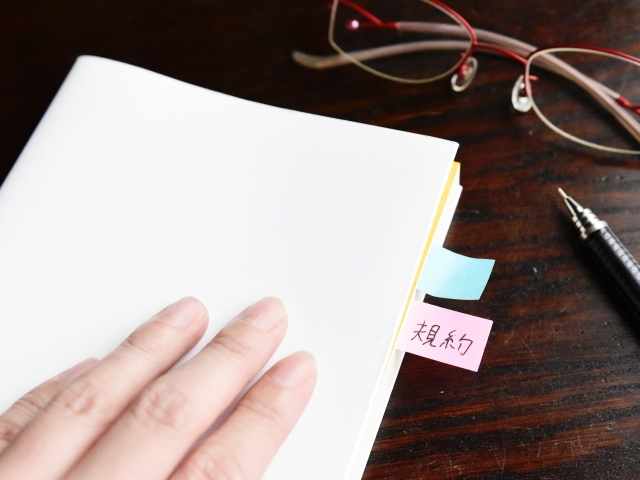 規約と書かれた付箋が挟まれた本