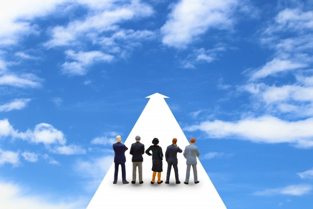 青空に浮かんだ矢印と人形