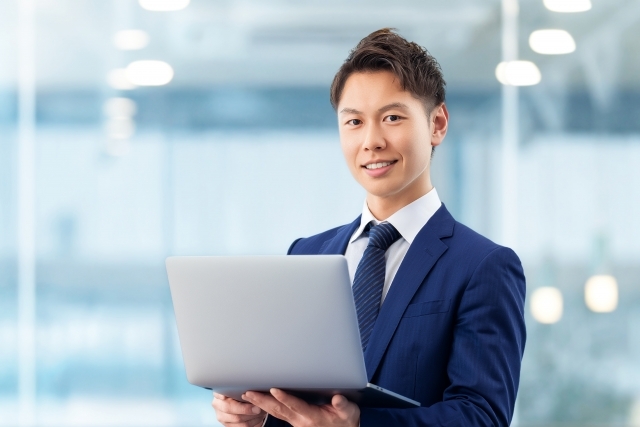 ノートパソコンを持つ男性