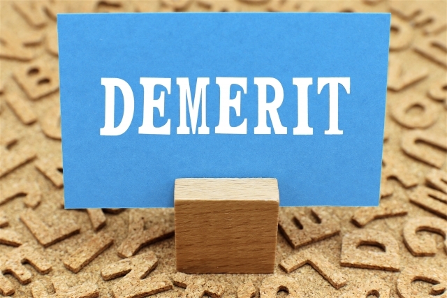 デメリットの文字が書かれた紙