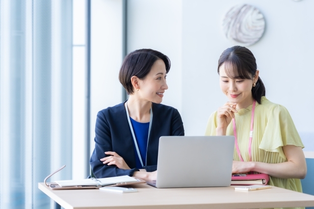 ノートパソコンを見て検討する女性