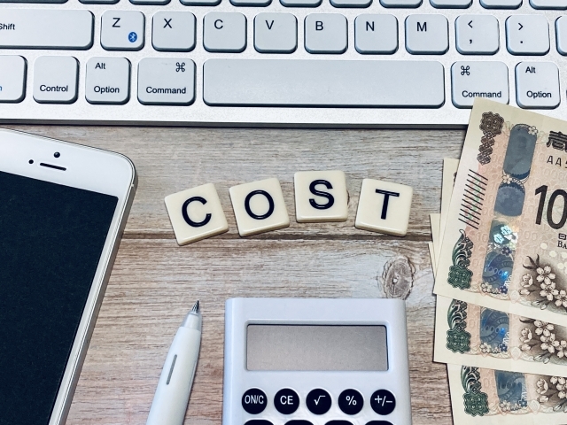 COSTの文字とスマホ、電卓、紙幣