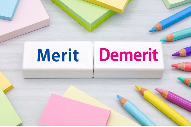 メリット・デメリットと書かれたオブジェ、色鉛筆、付箋