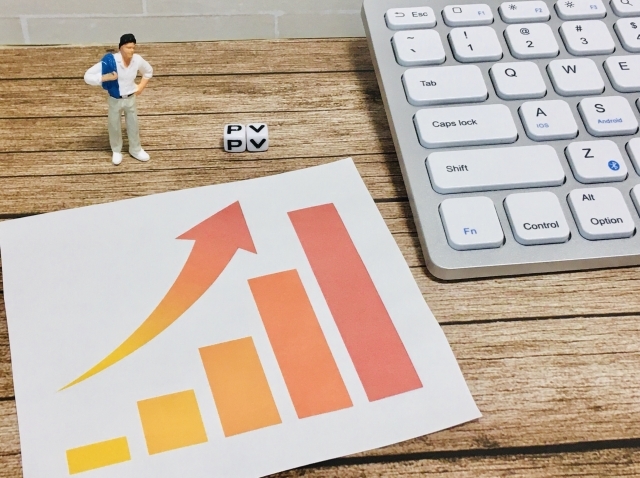 PVが右肩上がりするグラフとキーボード、人形