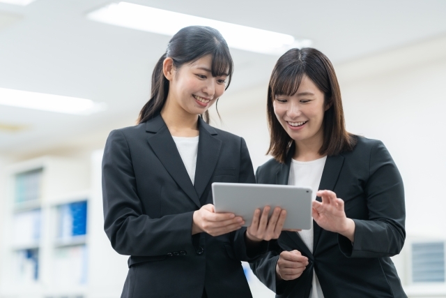 タブレットを見るスーツの女性