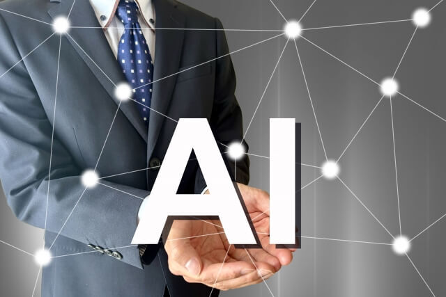 男性の手の上に浮かぶAIの文字