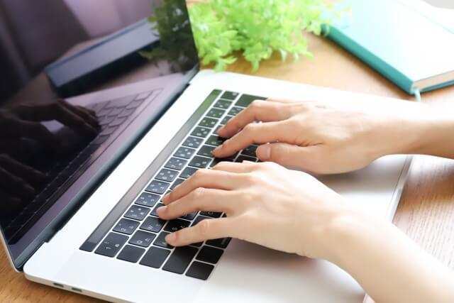 ノートパソコンを操作する人の手元