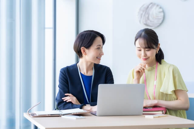 ノートパソコンの前で話す女性達