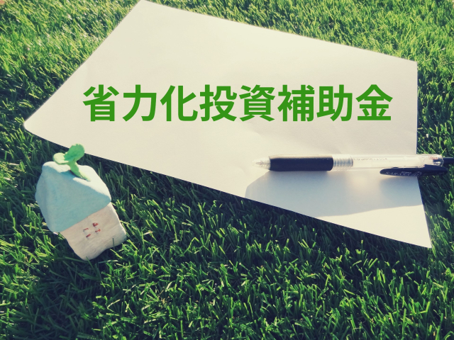 芝生の上の紙「省力化投資補助金」ロゴ